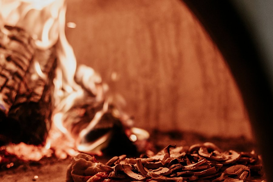 Pizza baking inside a wood-fired pizza oven